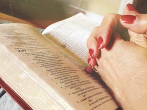 Hand praying over Bible